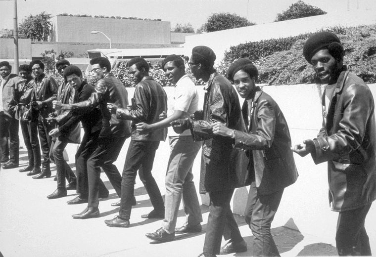 African Americans - Huey Newton and Bobby Seale founded the Black Panther Party in Oakland, California, in 1966 to protect black neighborhoods from police brutality. Their radical philosophy quickly made them a lightning rod for police harassment. The Panthers advocated exemption from the draft and reparations for slavery. The group also demanded the release of all black prisoners and encouraged African Americans to carry guns. At its peak, the Black Panther Party had two thousand members and several chapters. Gun battles with police in California, New York, and Chicago led to the arrest of several prominent members, including Huey Newton. This picture was taken on the second day of Newton's trial in San Francisco in July 1968. 